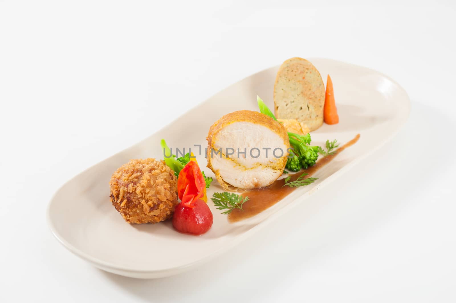 3 modern cuisine Prosciutto Wrapped Chicken with resotto and tamarind sauce, Fried mussaman curry, and Thai chicken spicy sausage on ceramic dish garnished with vegetables