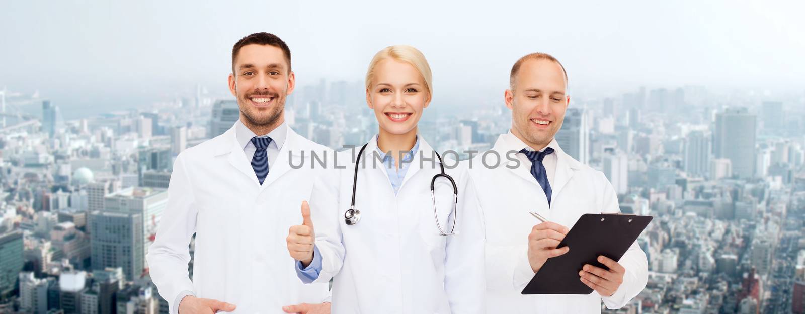 group of doctors showing thumbs up over white by dolgachov