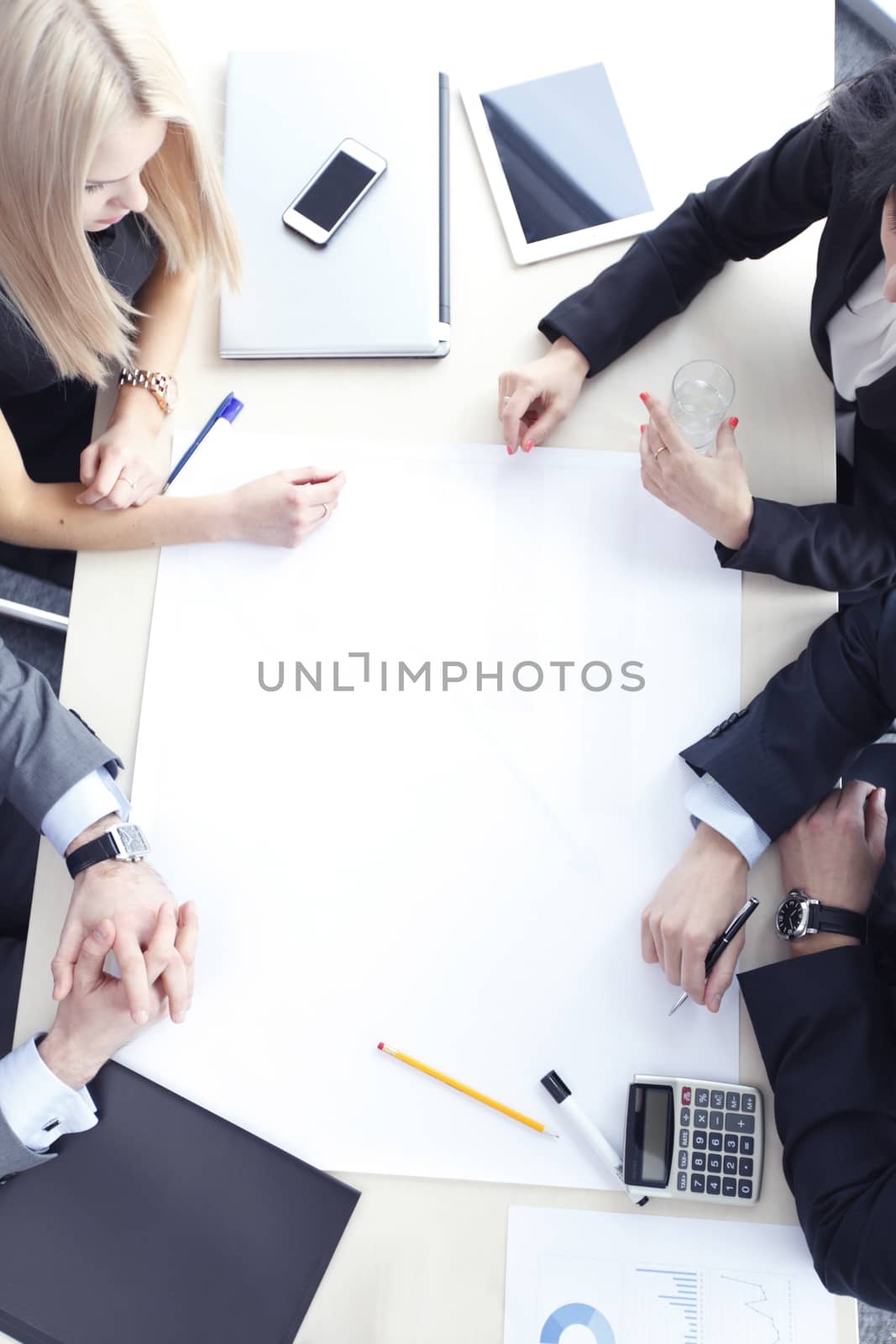 Business people sitting at table with electronic devices on meeting