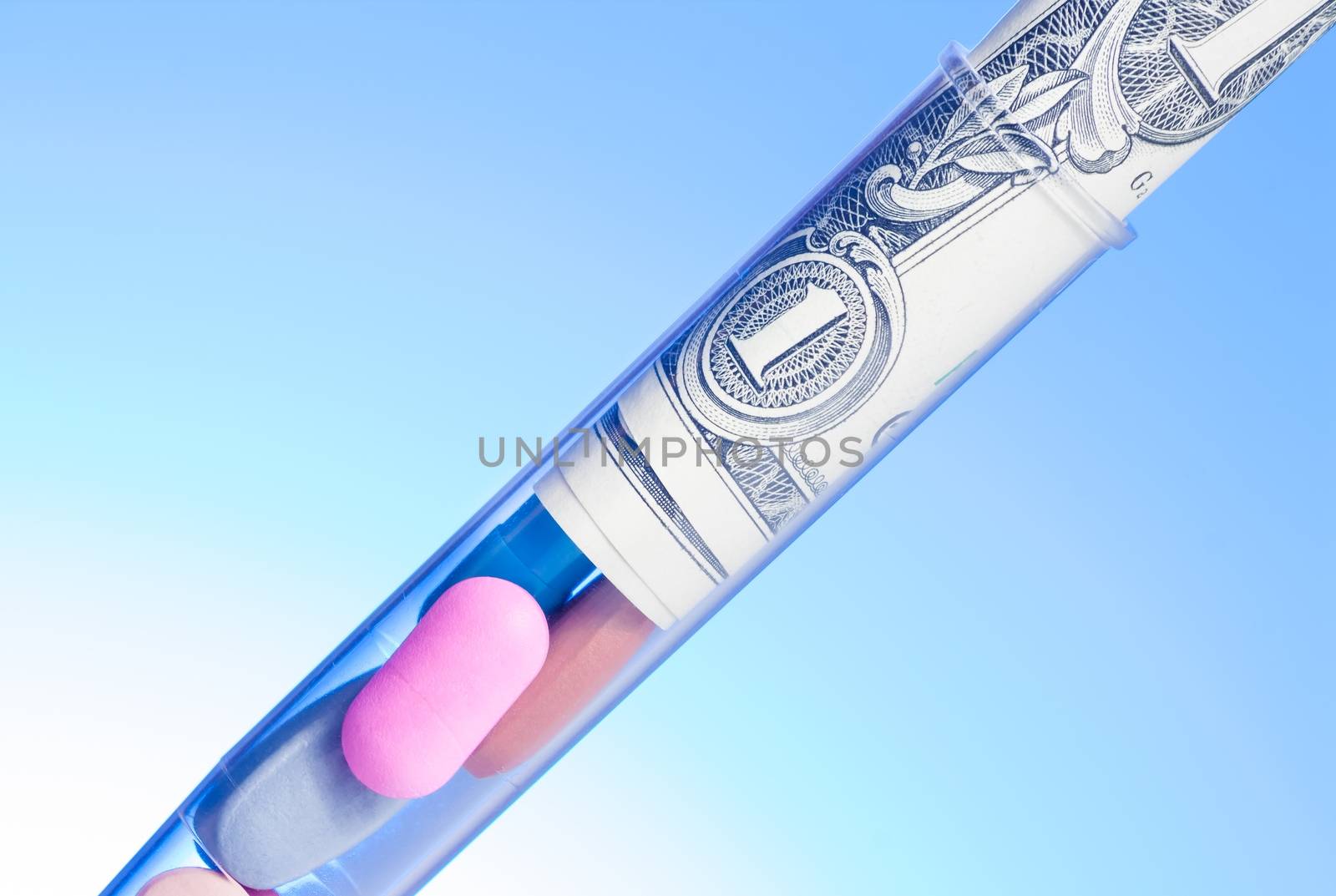 colorful pills and dollars in test tube, cost of medical health care on light blue background