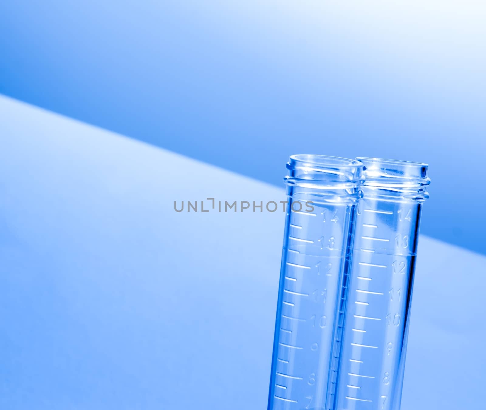 empty test tubes in laboratory on table and blue light tint background with space for text
