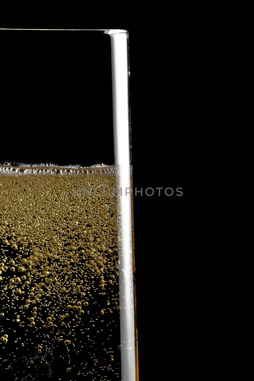 detail of  a flute of champagne with golden bubbles on black background and space for text