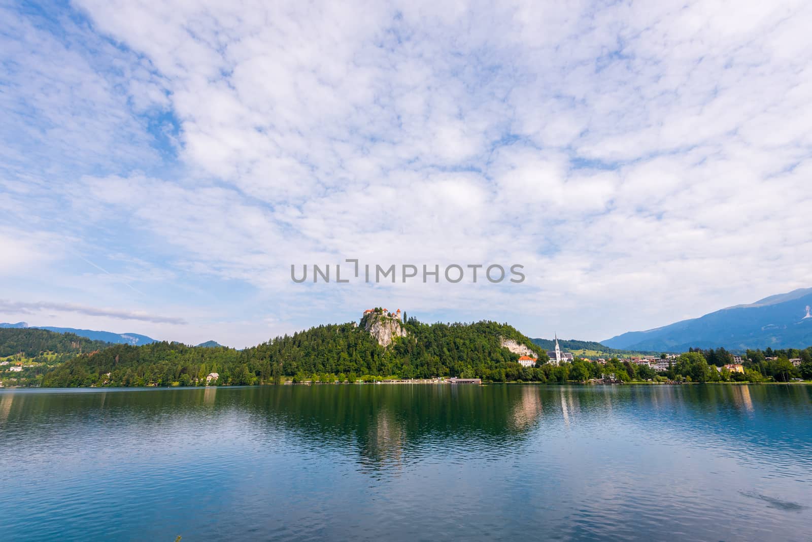 Bled Castle on a Rock at Bled Lake in Slovenia Reflected on Water Surface with Cloudy Sky