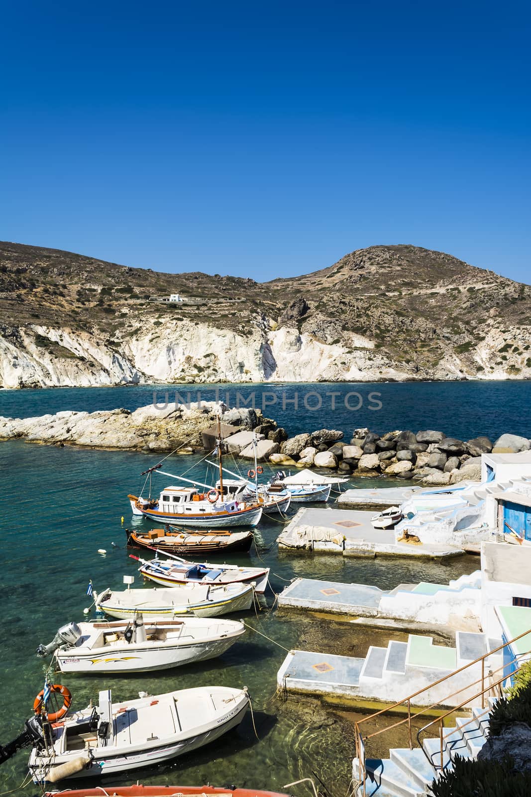 Mandrakia traditional Greek fish village with sirmate  - fish boats and a dog at Milos island, Greece.