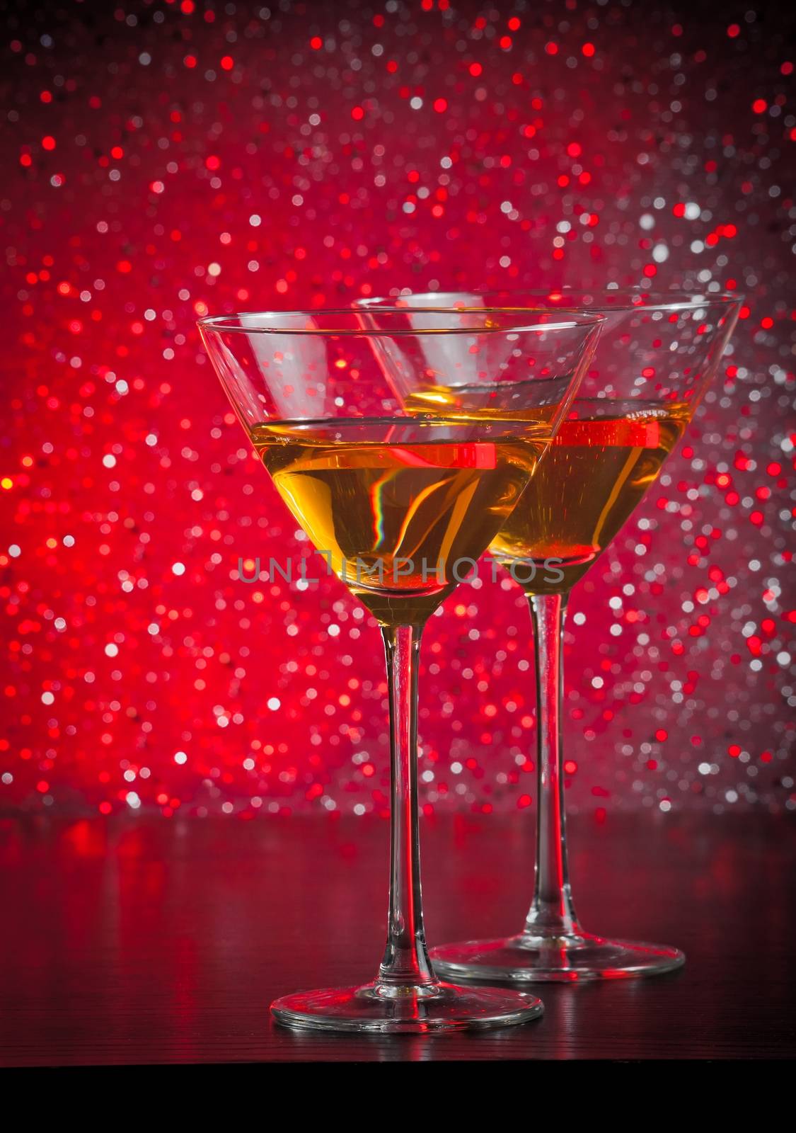 two glasses of  fresh cocktail on red tint light background on bar table