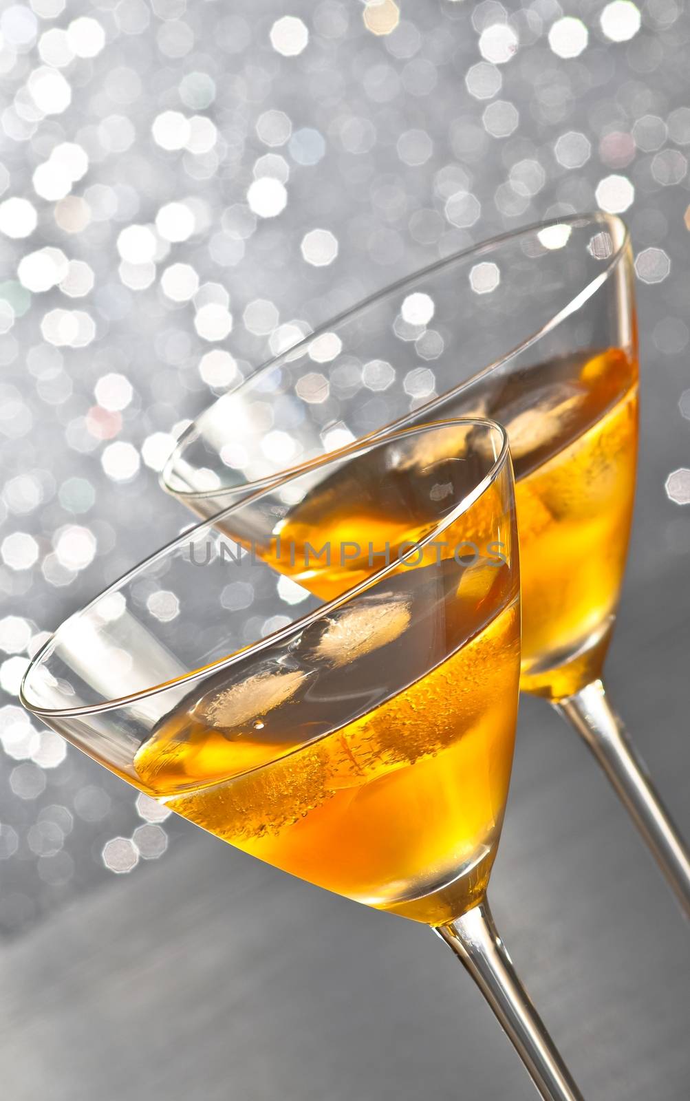 two glasses of fresh cocktail with ice on silver tint light bokeh background