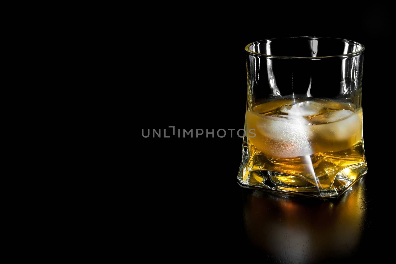 glass of whiskey with ice  with space for text on black background