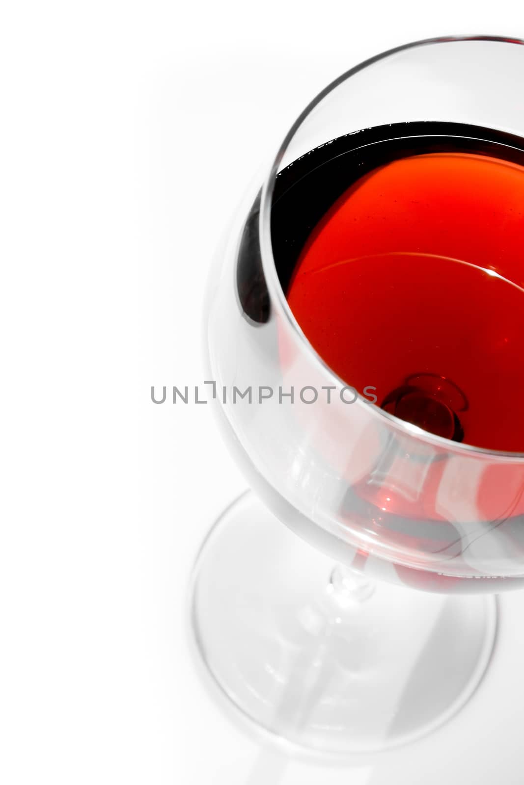 top of view of half red wine glass with space for text under daily light by donfiore