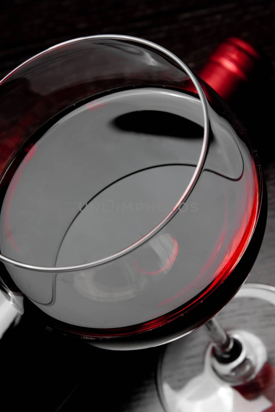 top of view of red wine glass near bottle by donfiore
