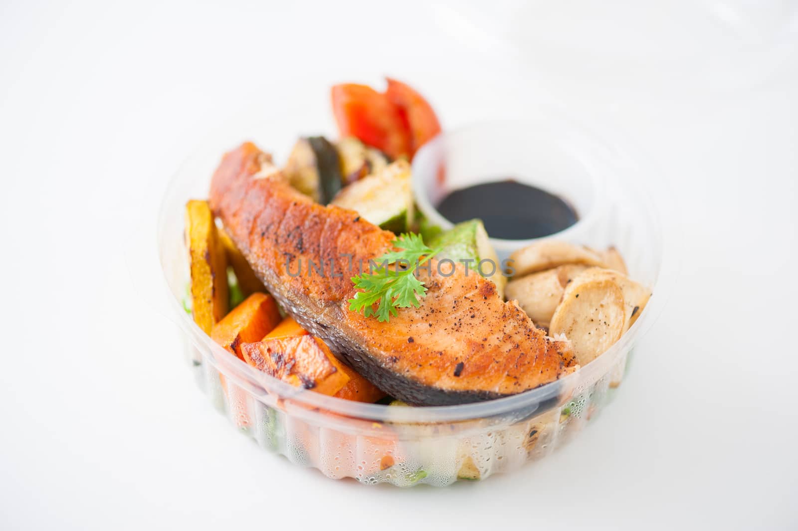 Salmon steak and grilled vegetables cooked by clean food concept with Japanese sesame soy sauce in lunch box