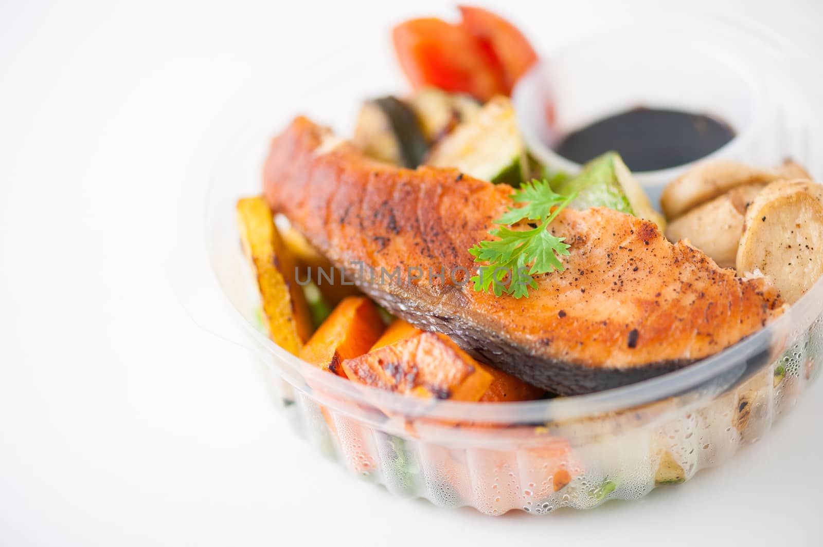Salmon steak and grilled vegetables cooked by clean food concept with Japanese sesame soy sauce in lunch box