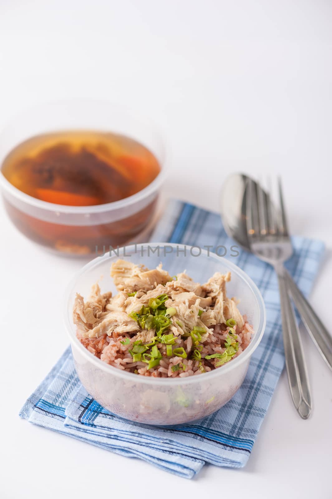 Brown rice gruel with chicken breast with vegetables soup cooked by clean food concept in separate lunch box on white table