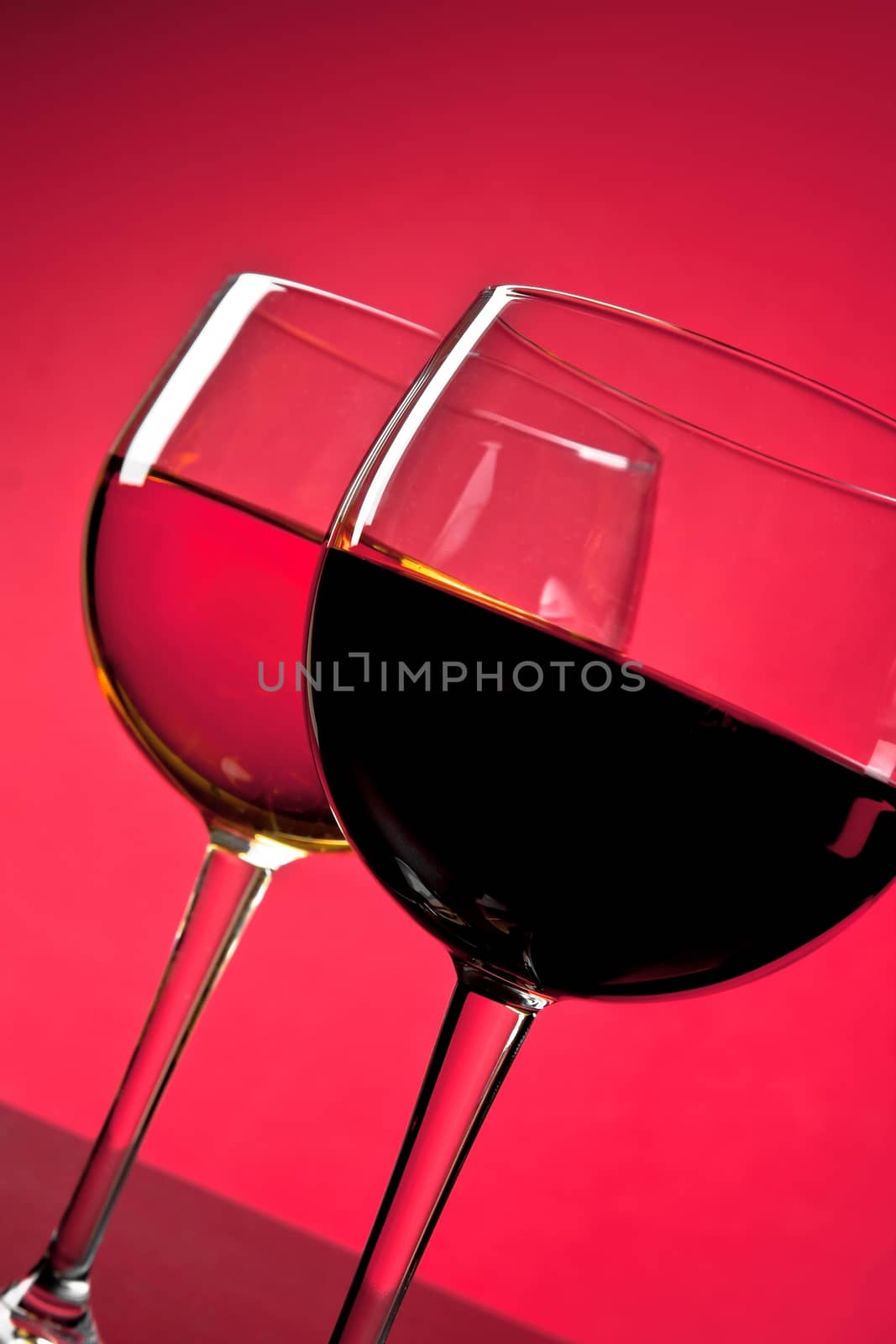 detail of red and white wine glasses on red background