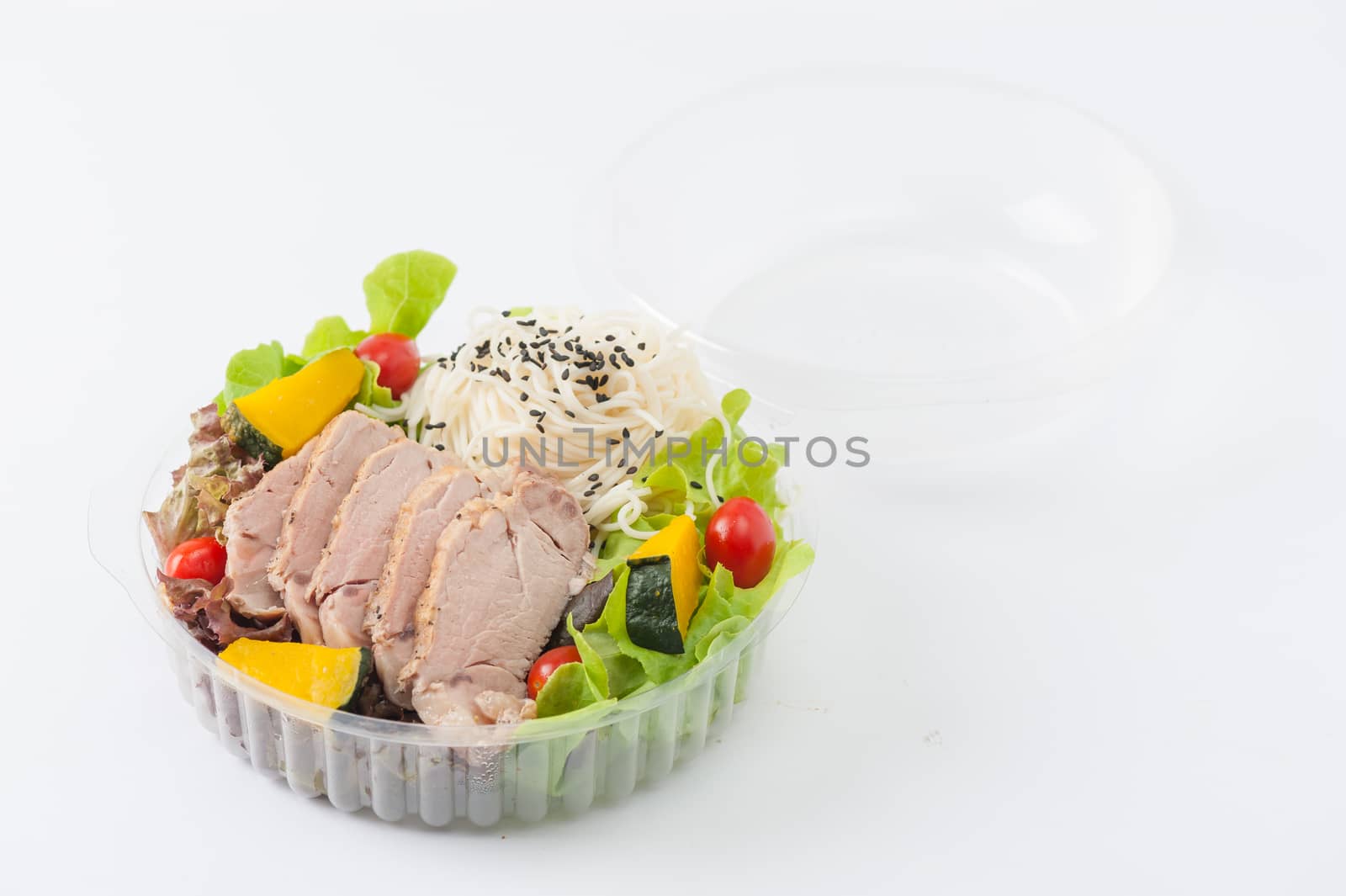Salad with roasted pork and soba noodles by clean food concept in lunch box on white table