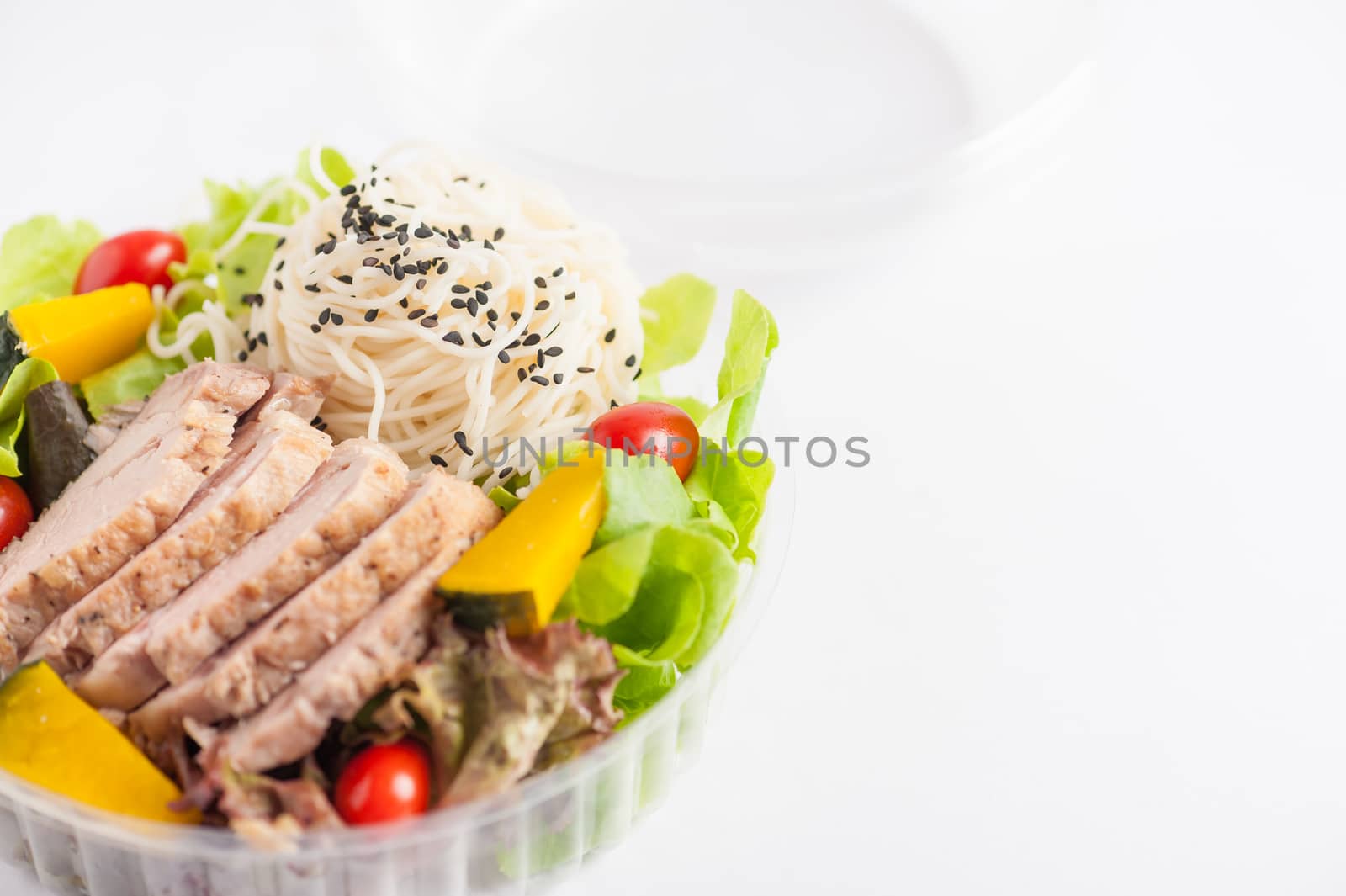 Salad with roasted pork and soba noodles by clean food concept in lunch box on white table