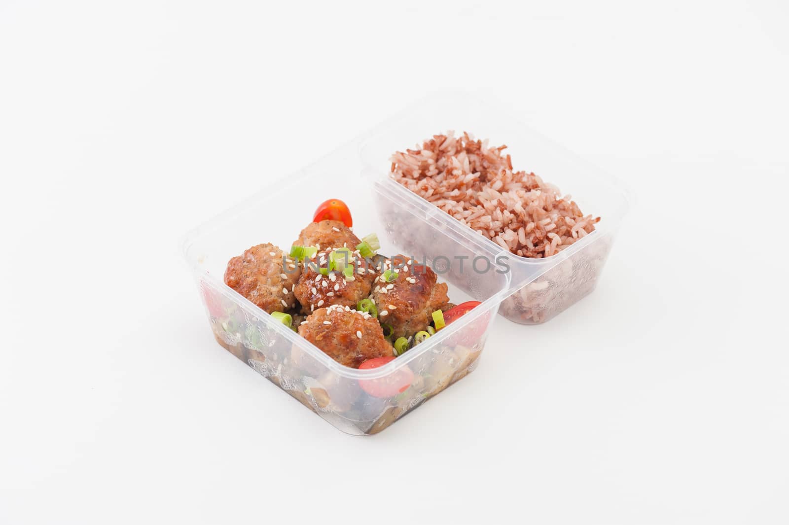 Tsukune (Japanese chicken meatballs) cooked by clean food concept with brown rice in lunch box on white table