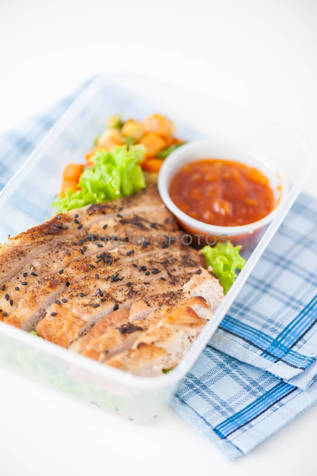 Roasted pork with three flavoured (sweet, sour, spicy) sauce cooked by clean food concept with vegetables in lunch box