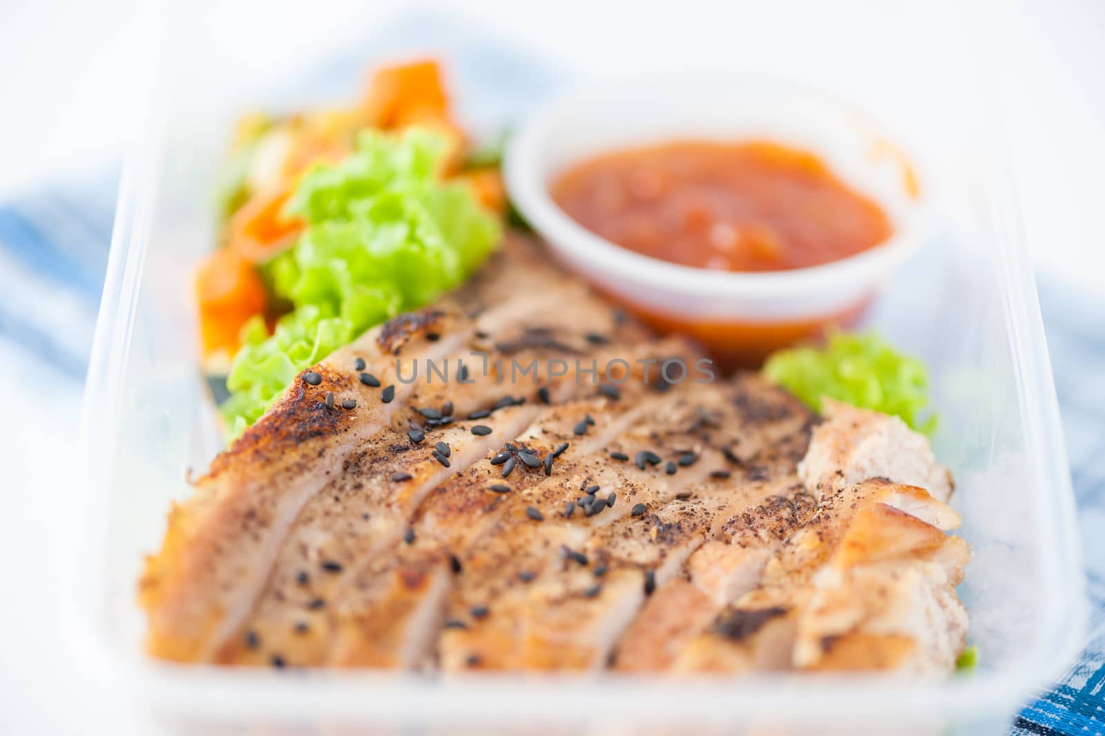 Roasted pork with three flavoured (sweet, sour, spicy) sauce cooked by clean food concept with vegetables in lunch box