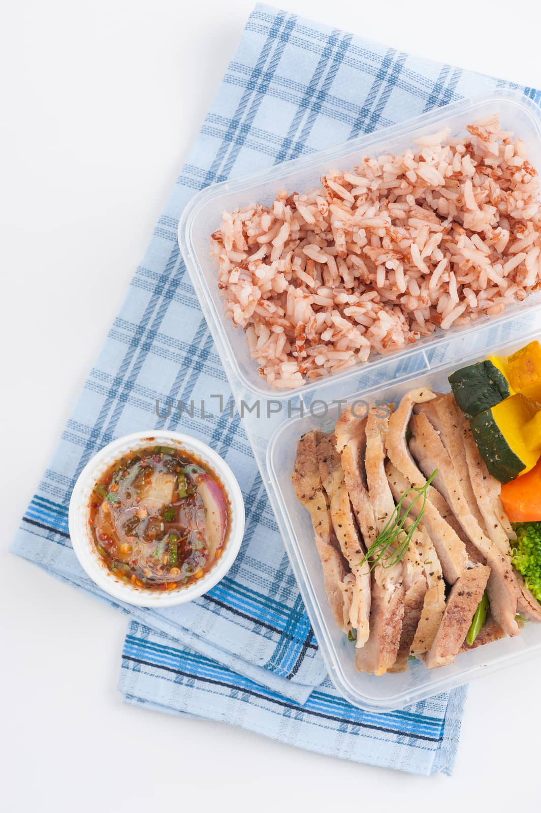 Roasted pork tenderloin with vegetables cooked by clean food concept with brown rice and Northern Thai local sauce on white table