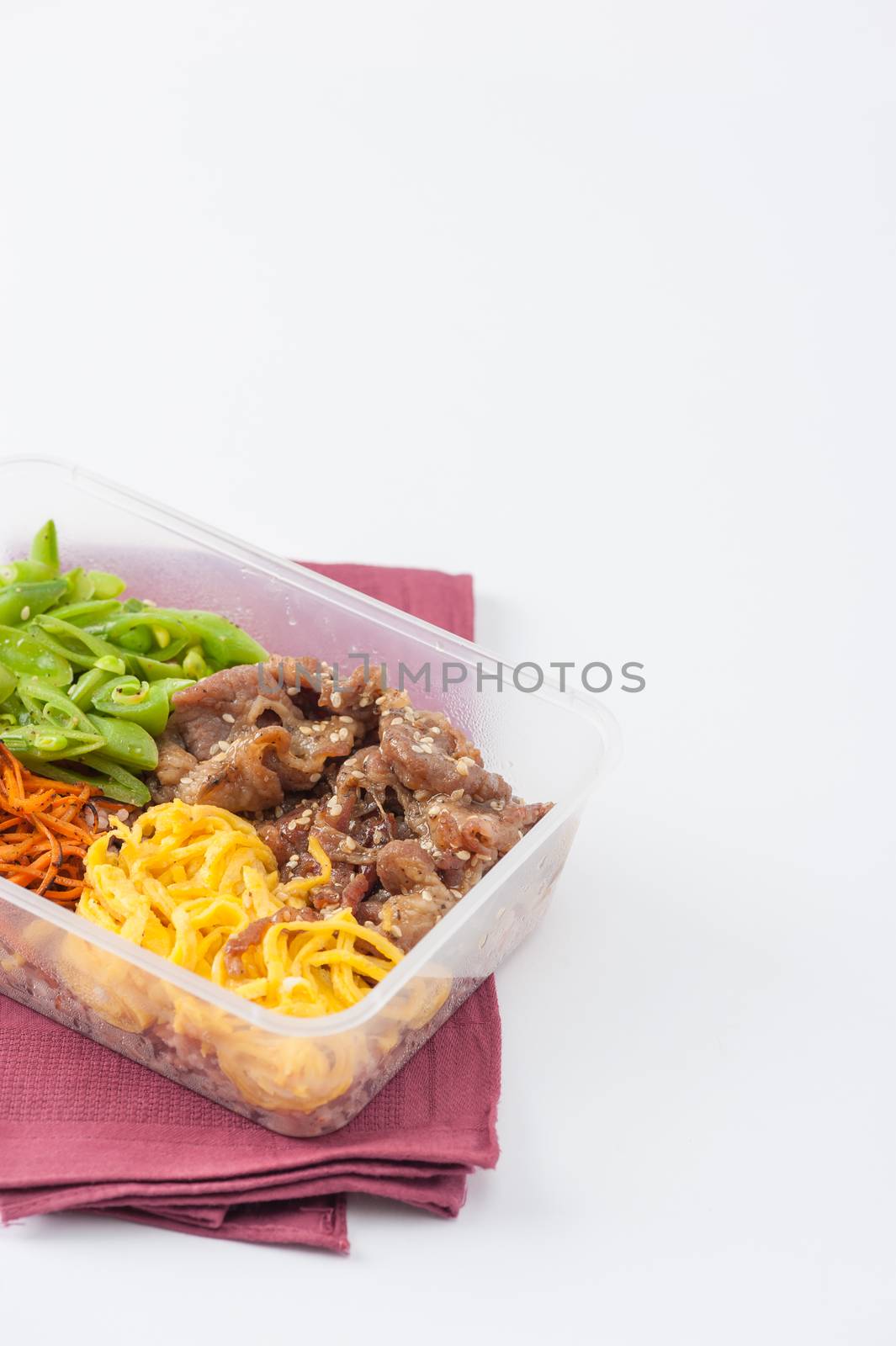 Bibimbub in clean food style. Brown rice with roasted pork, egg, and vegetables on white table