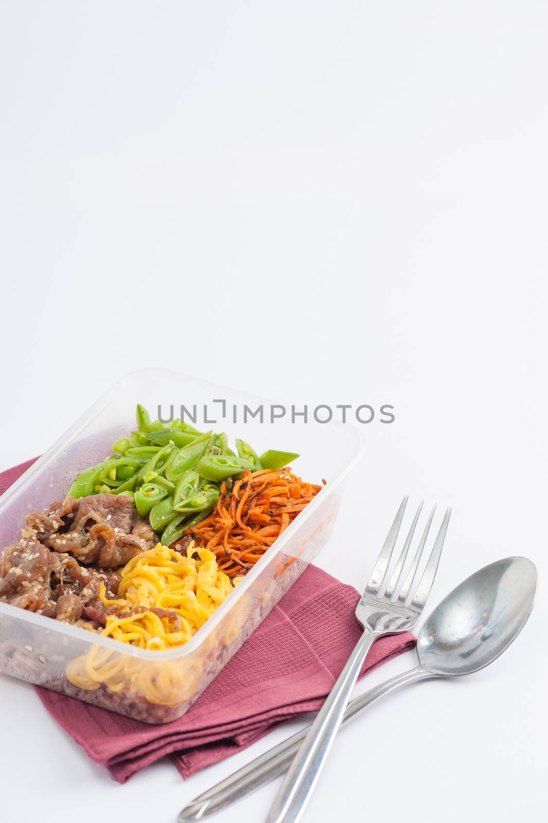 Bibimbub in clean food style. Brown rice with roasted pork, egg, and vegetables on white table