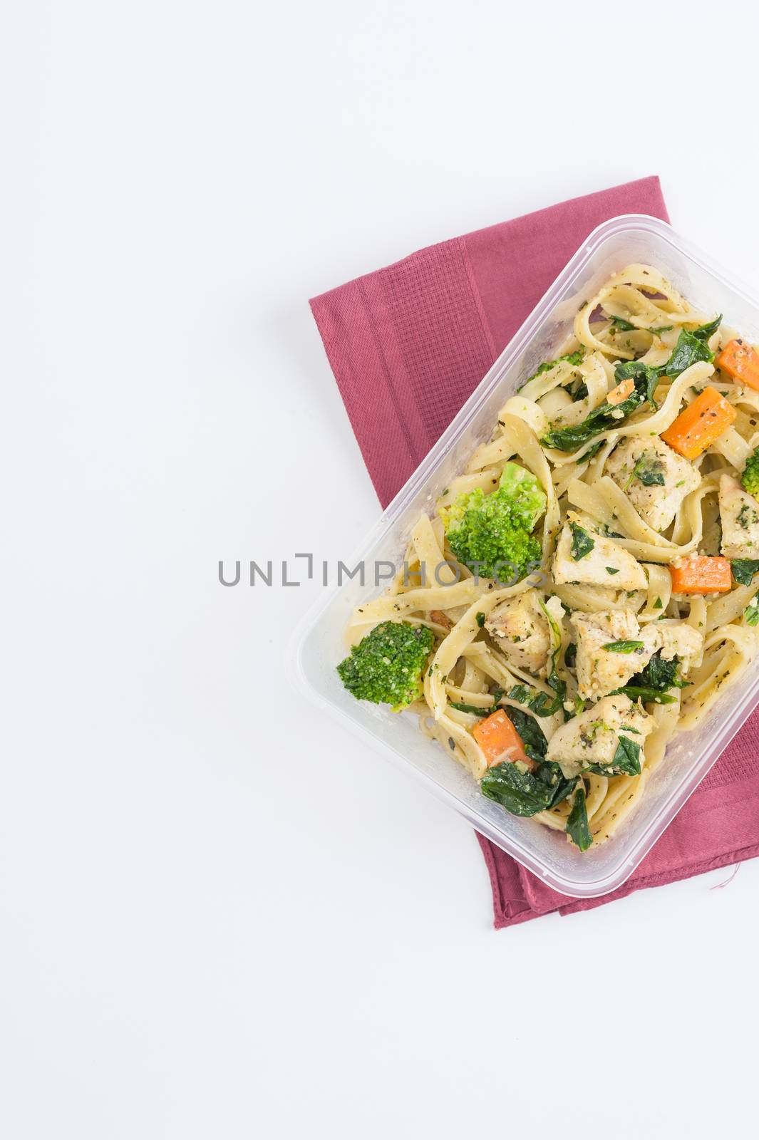 Fettuccine pesto sauce with spinach, grilled fish and vegetables cooked by clean food concept in lunch box on white table