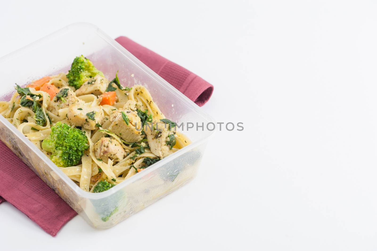 Fettuccine pesto sauce with spinach, grilled fish and vegetables cooked by clean food concept in lunch box on white table