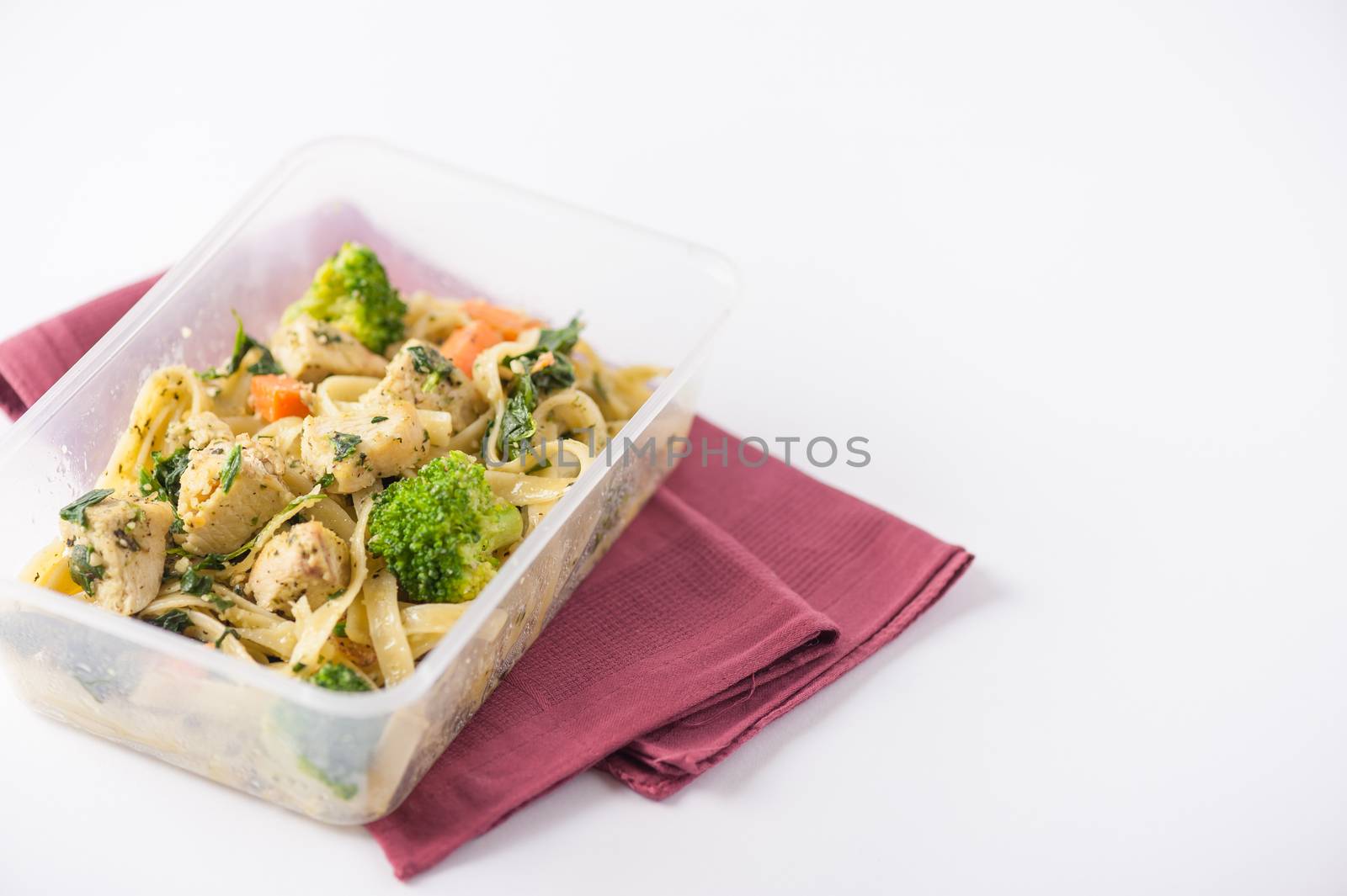 Fettuccine pesto sauce with spinach, grilled fish and vegetables cooked by clean food concept in lunch box on white table