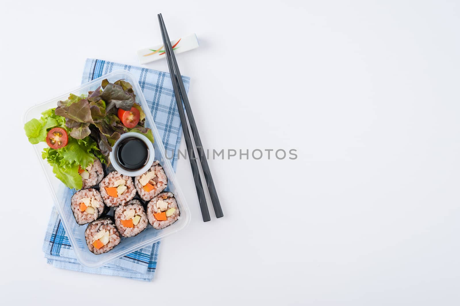 Japanese style brown rice maki with grilled chicken, grilled pork, and grilled tofu cooked by clean food concept in lunch box on white table
