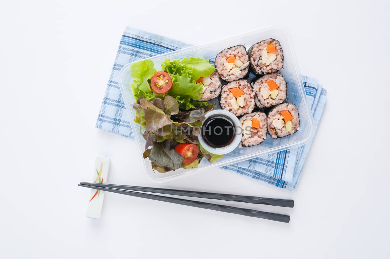 Japanese style brown rice maki with grilled chicken, grilled pork, and grilled tofu cooked by clean food concept in lunch box on white table