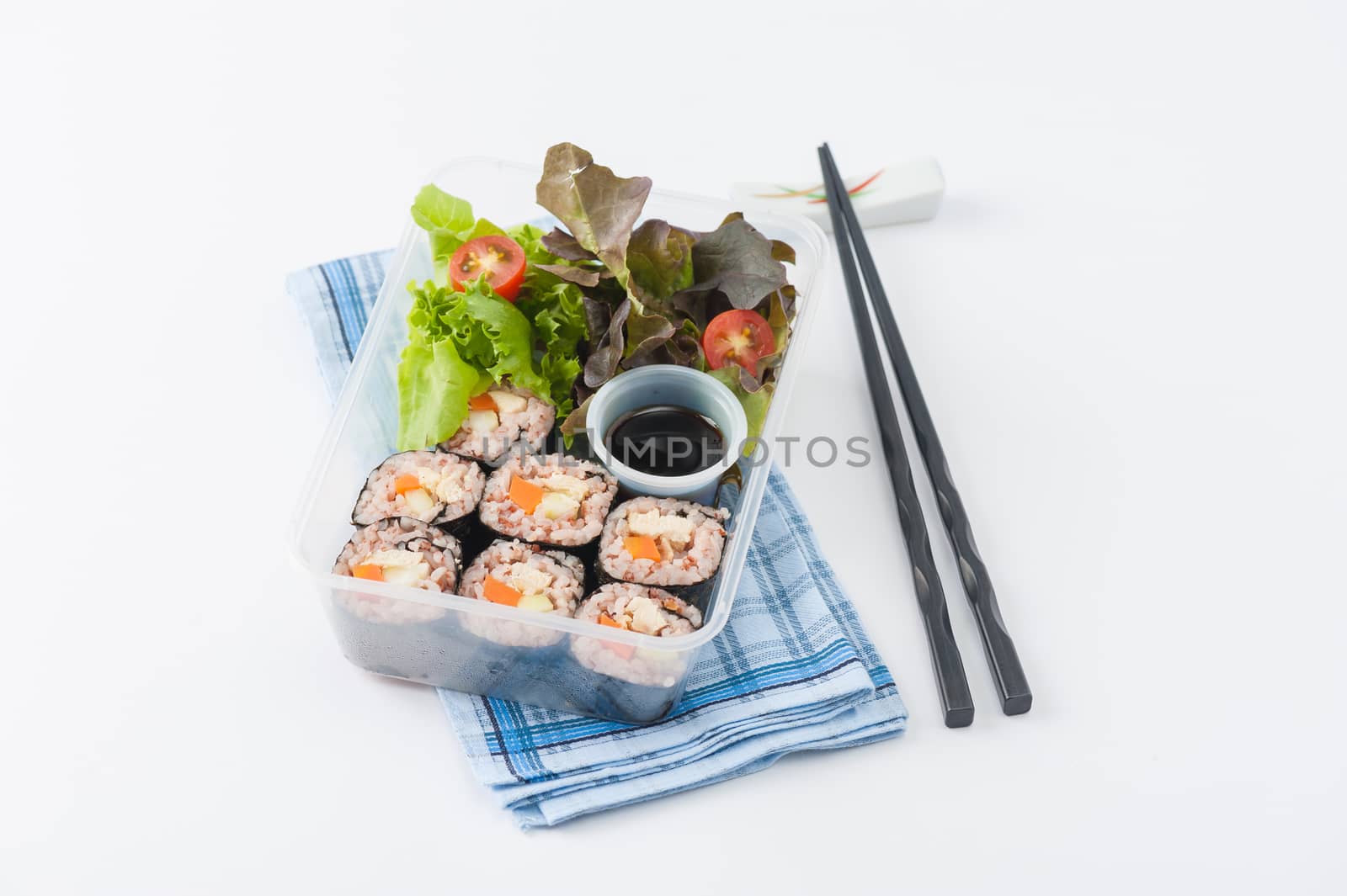 Japanese style brown rice maki with grilled chicken, grilled pork, and grilled tofu cooked by clean food concept in lunch box on white table