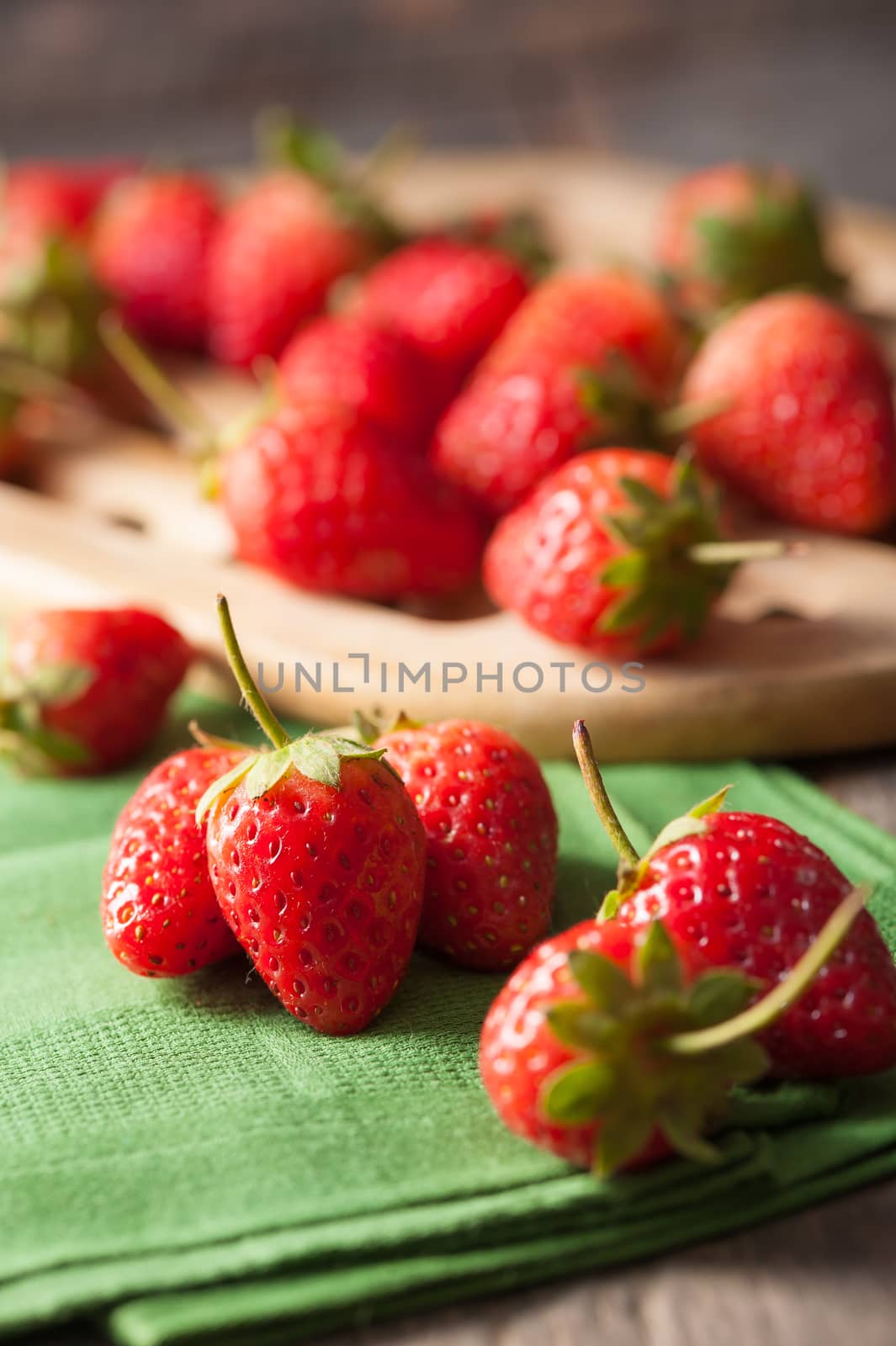 Strawberries on wood background in vintage style with low key scene.