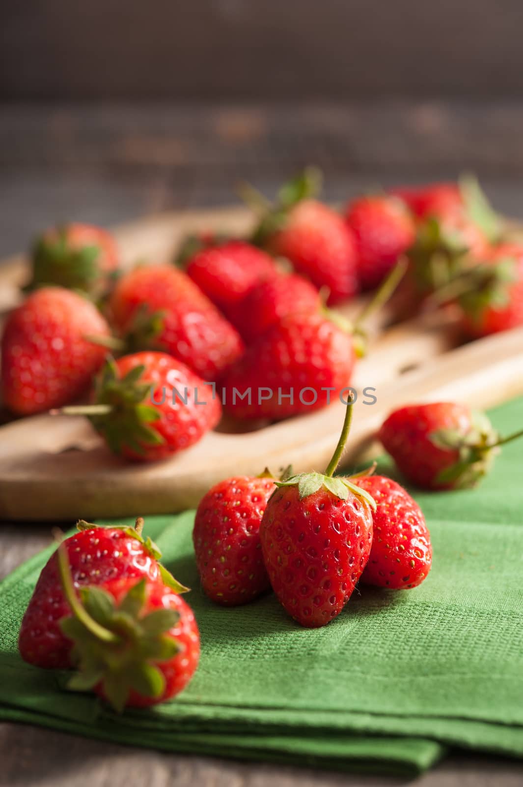 Strawberries on wood background in vintage style with low key scene.