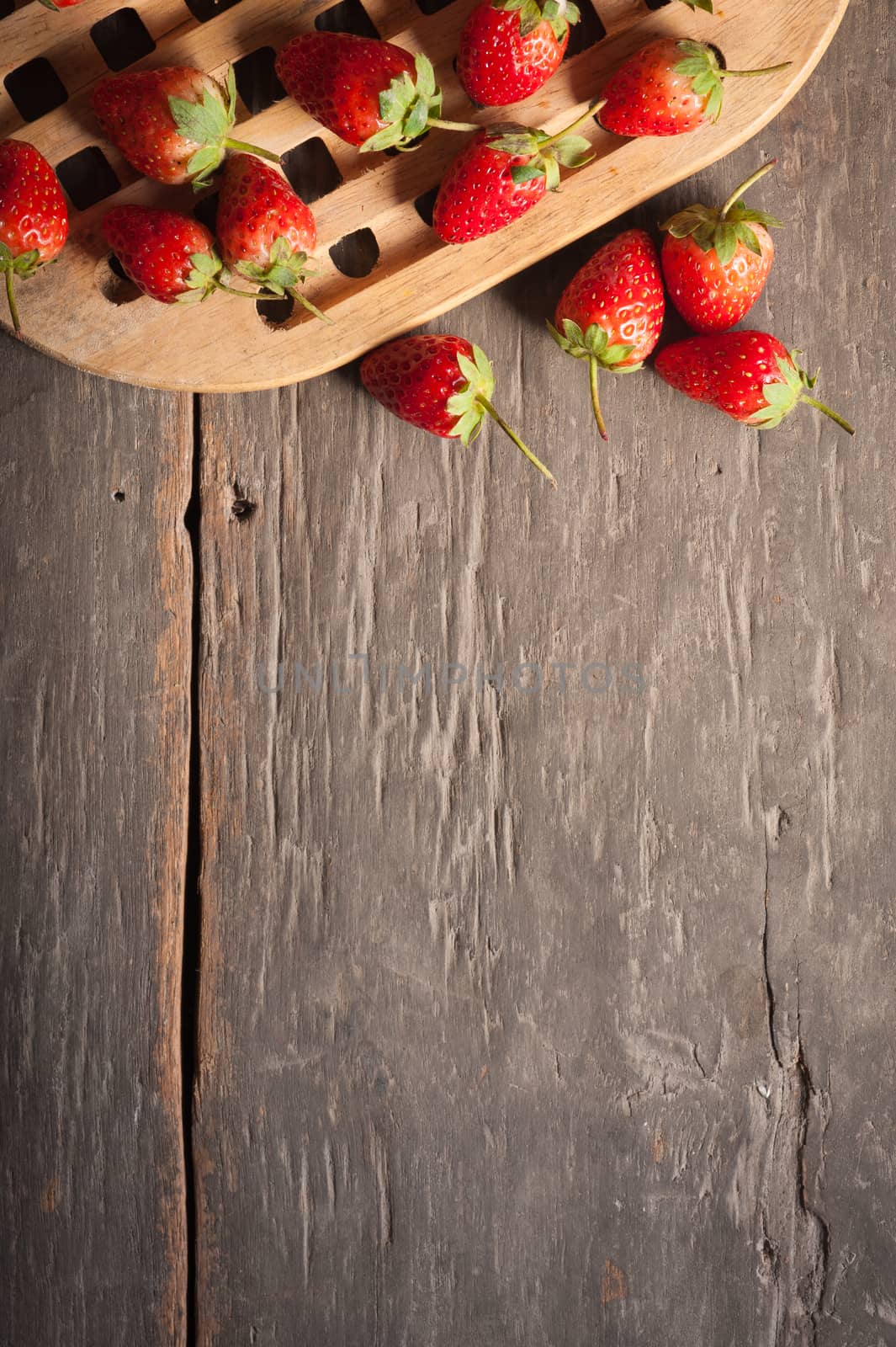 Strawberries on wood background in vintage style with low key scene.
