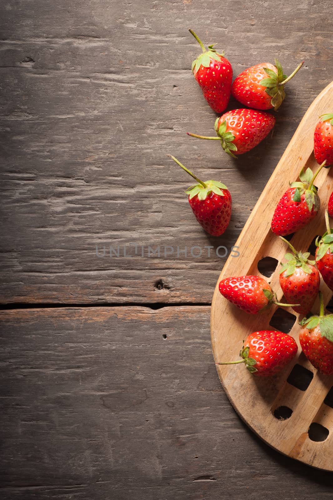Strawberries on wood background in vintage style with low key scene.
