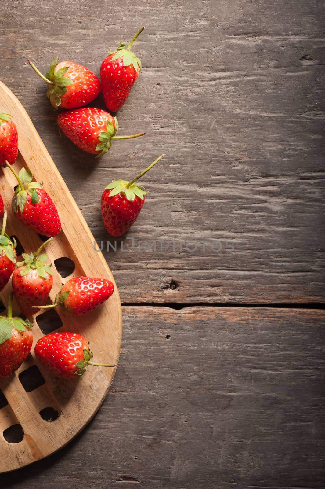 Strawberries on wood background in vintage style with low key scene.