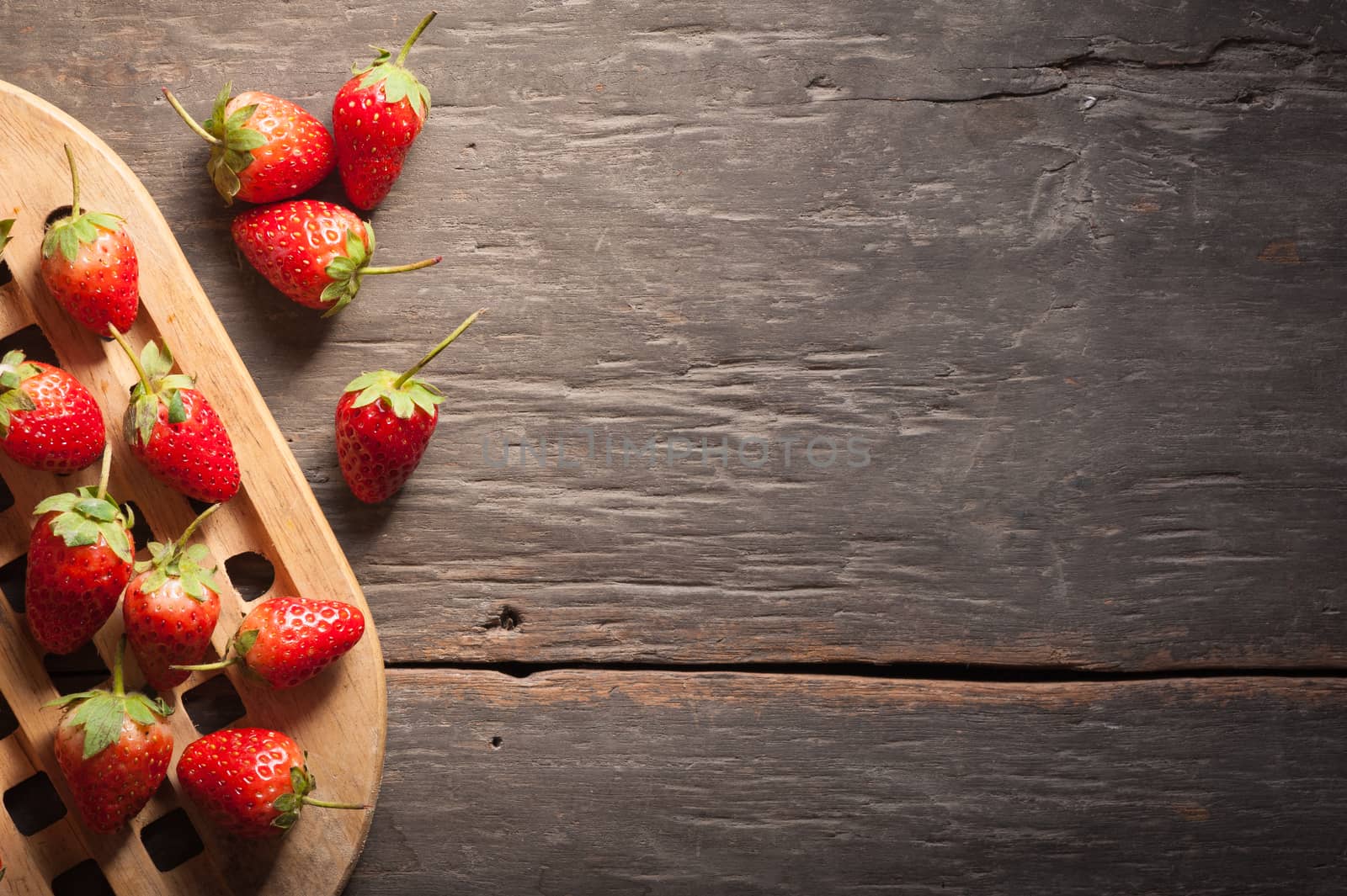Strawberries on wood background in vintage style with low key scene.