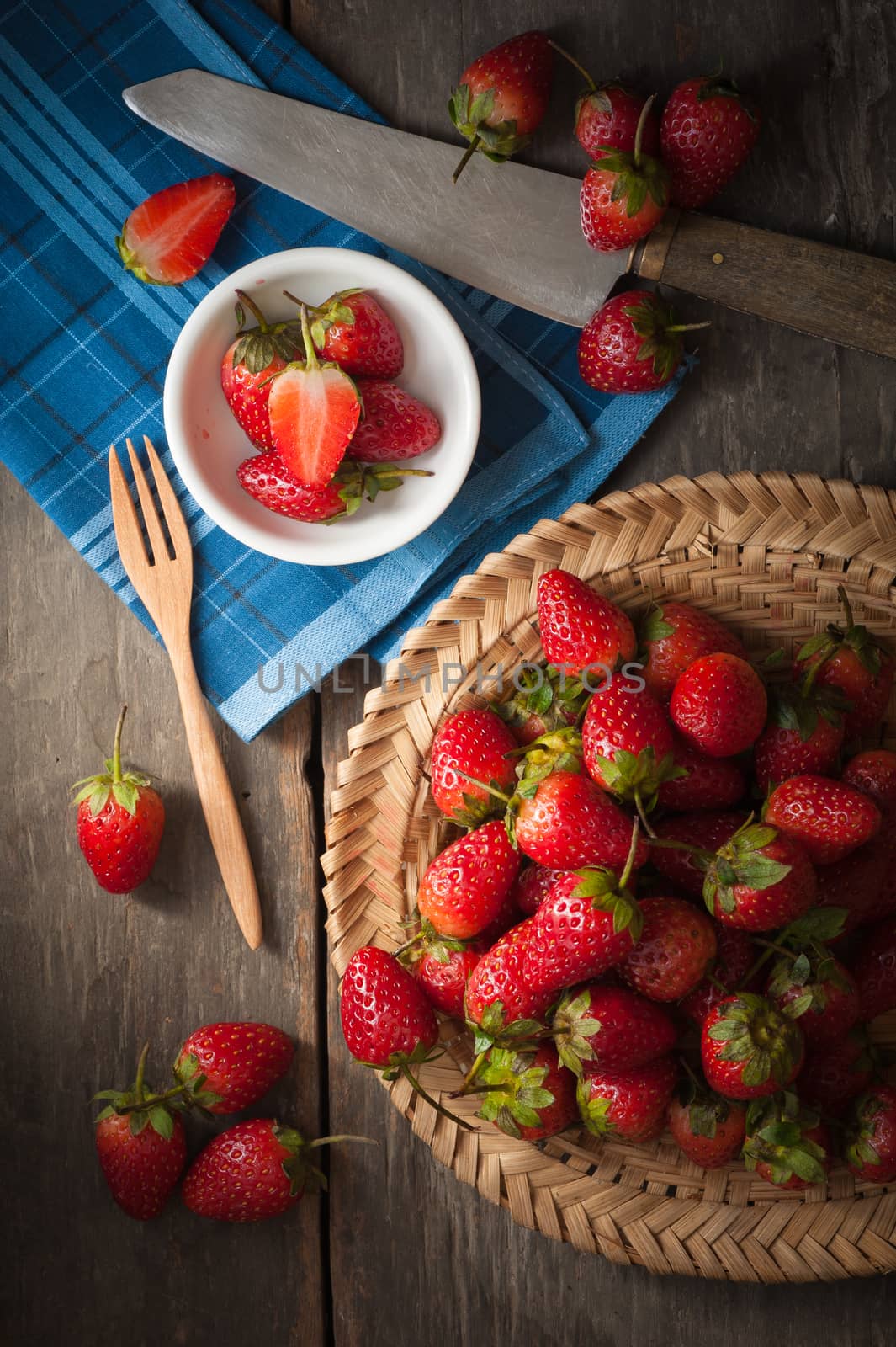 Strawberries on wood background in vintage style with low key scene.