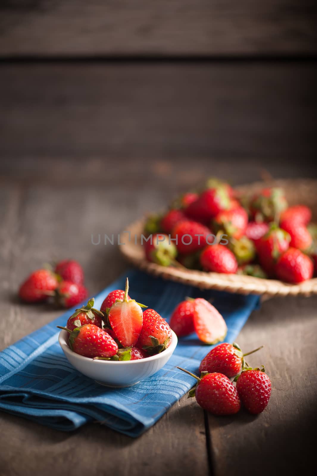 Strawberries on wood background in vintage style with low key scene.