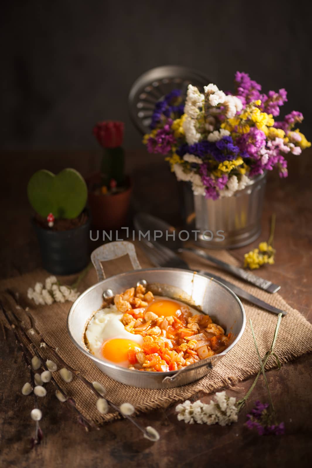 Vietnamese style fried egg in metal pan with white pork and onion on wood table in vintage style with low key scene