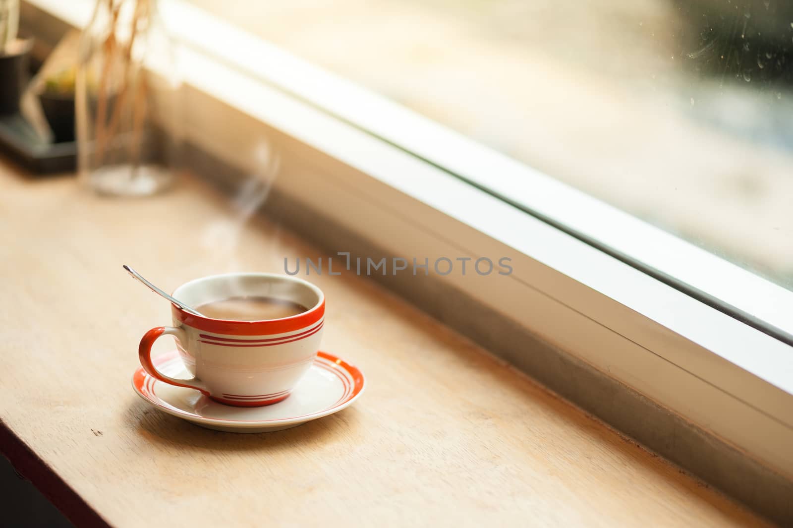 Milk coffee in coffee cup on wood bar with morning scene