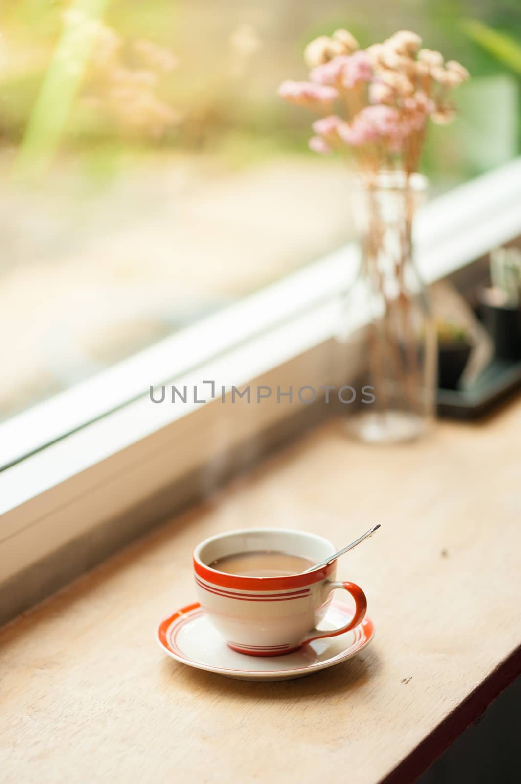 Milk coffee in coffee cup on wood bar with morning scene