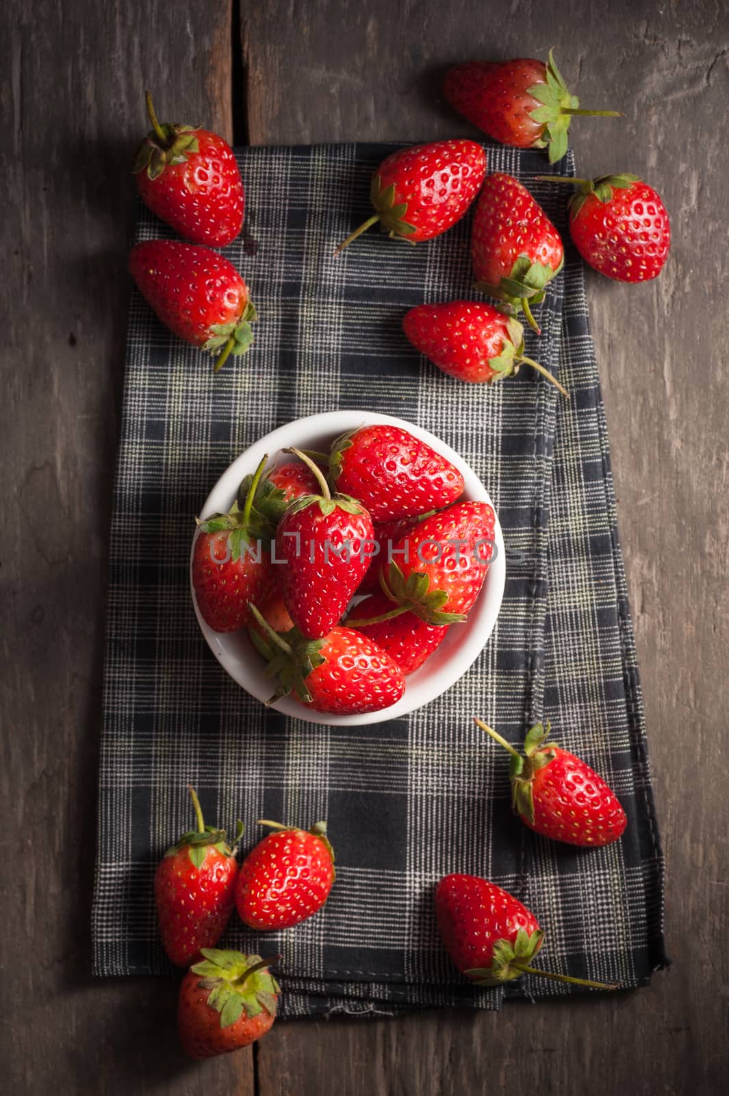 Strawberries on wood background in vintage style with low key scene.