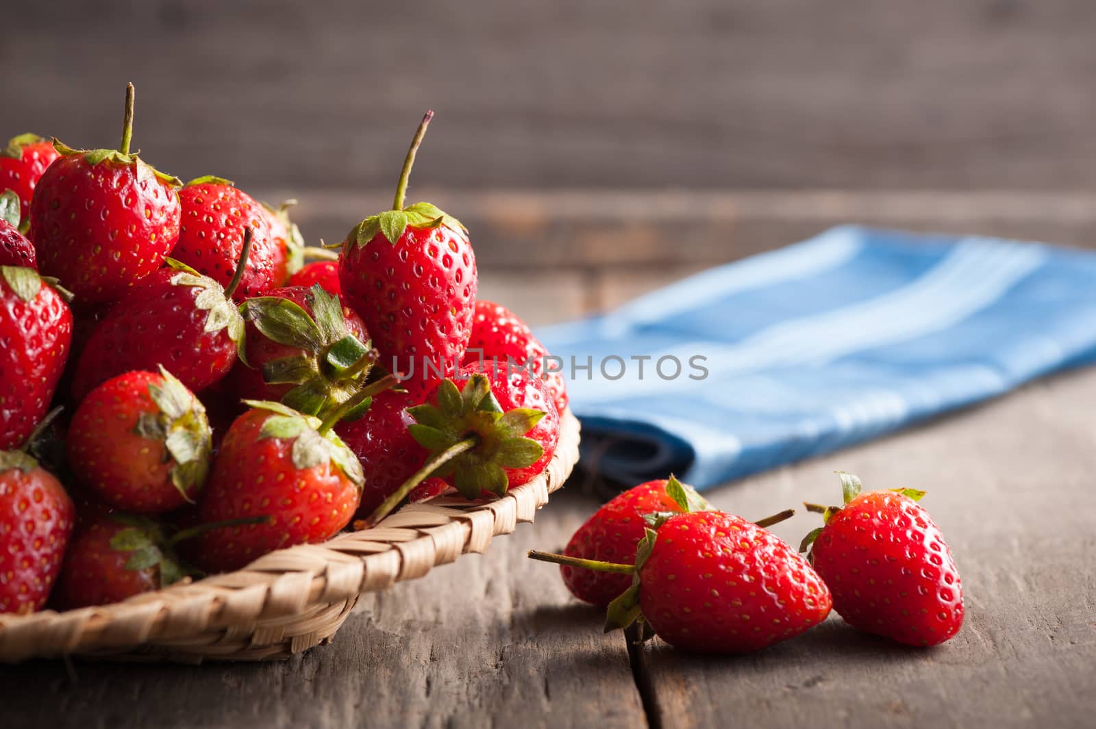 Strawberries on wood background in vintage style with low key scene.
