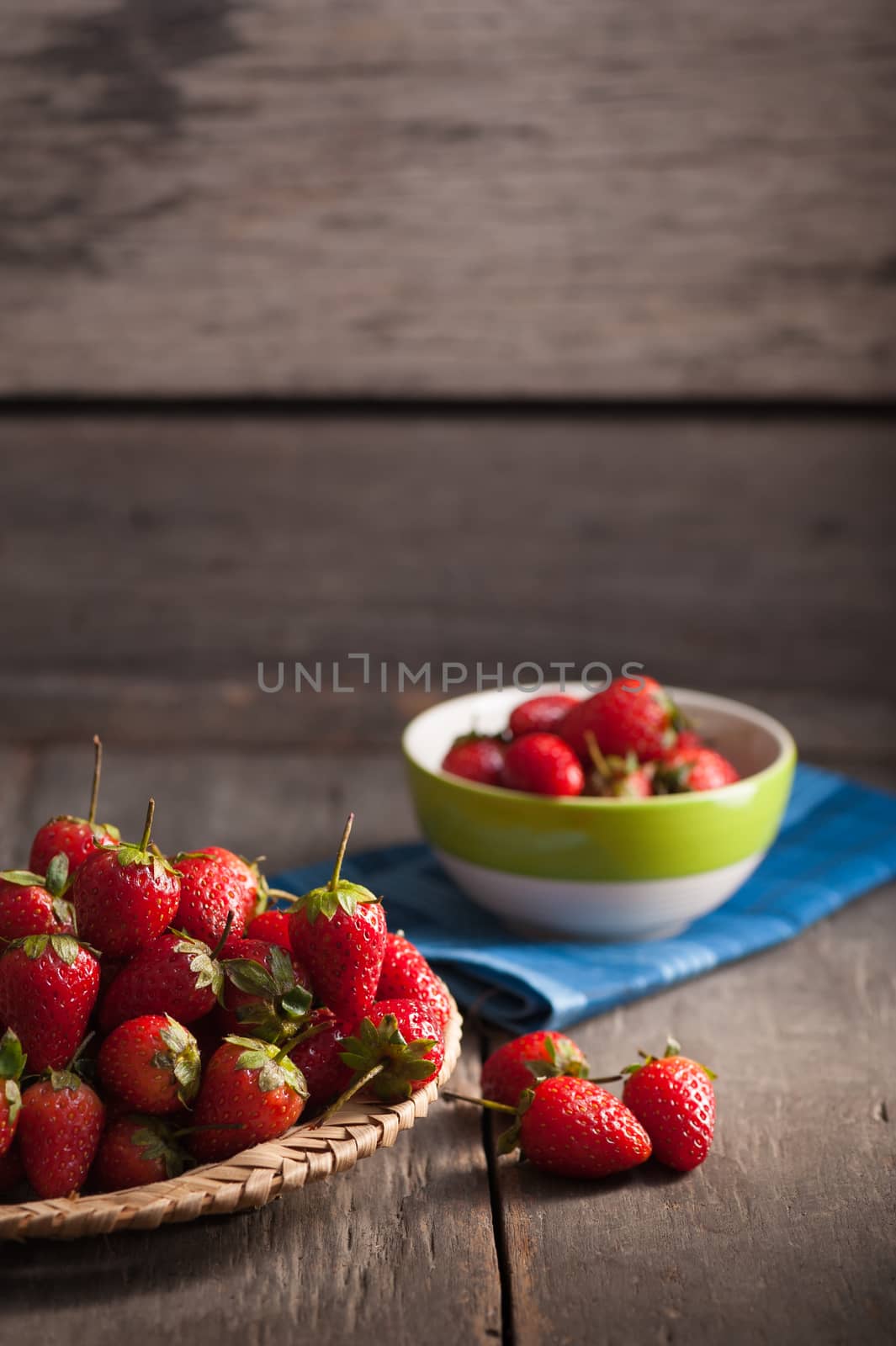 Strawberries on wood background in vintage style with low key scene.