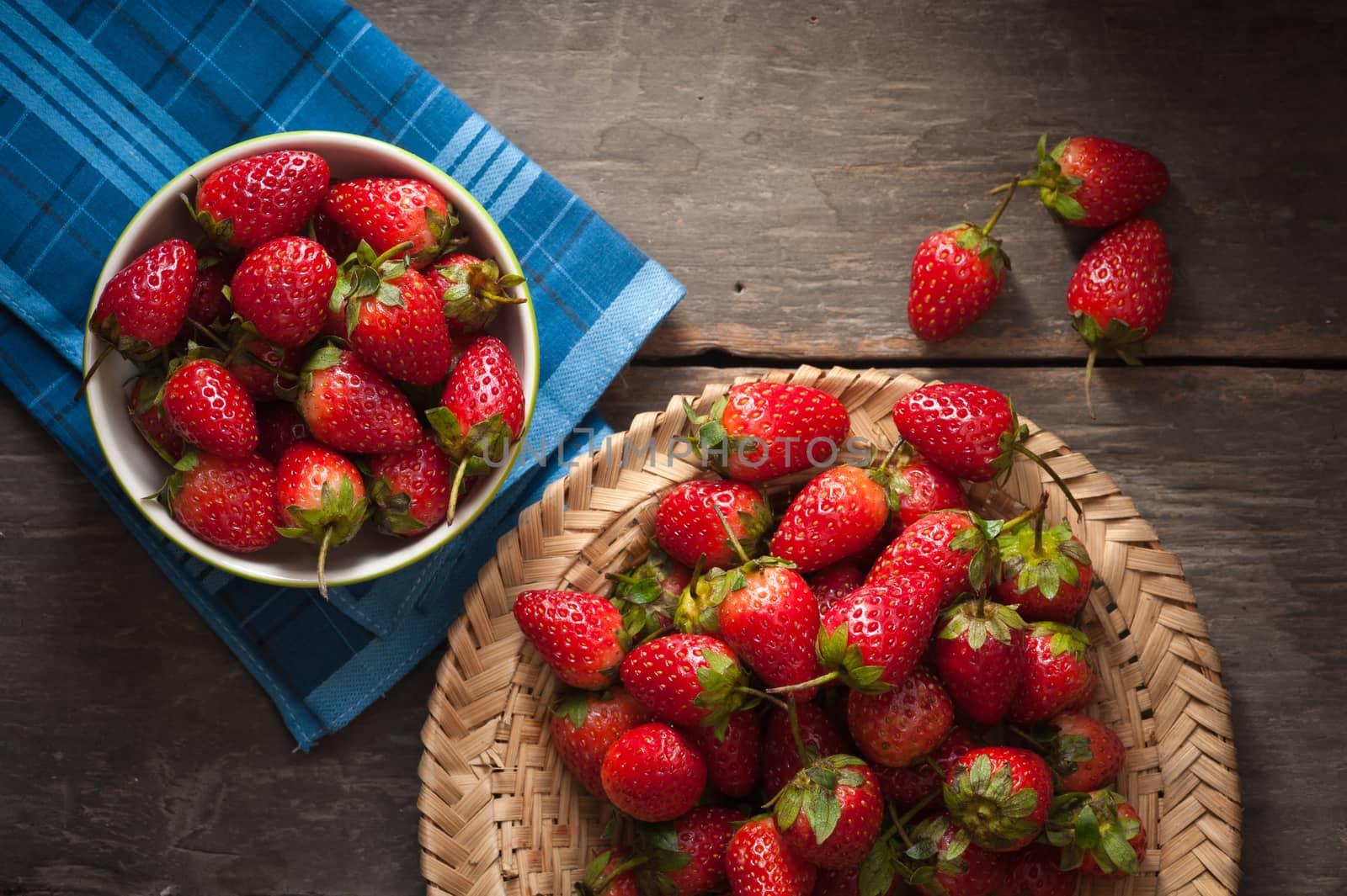 Strawberries on wood background in vintage style with low key scene.