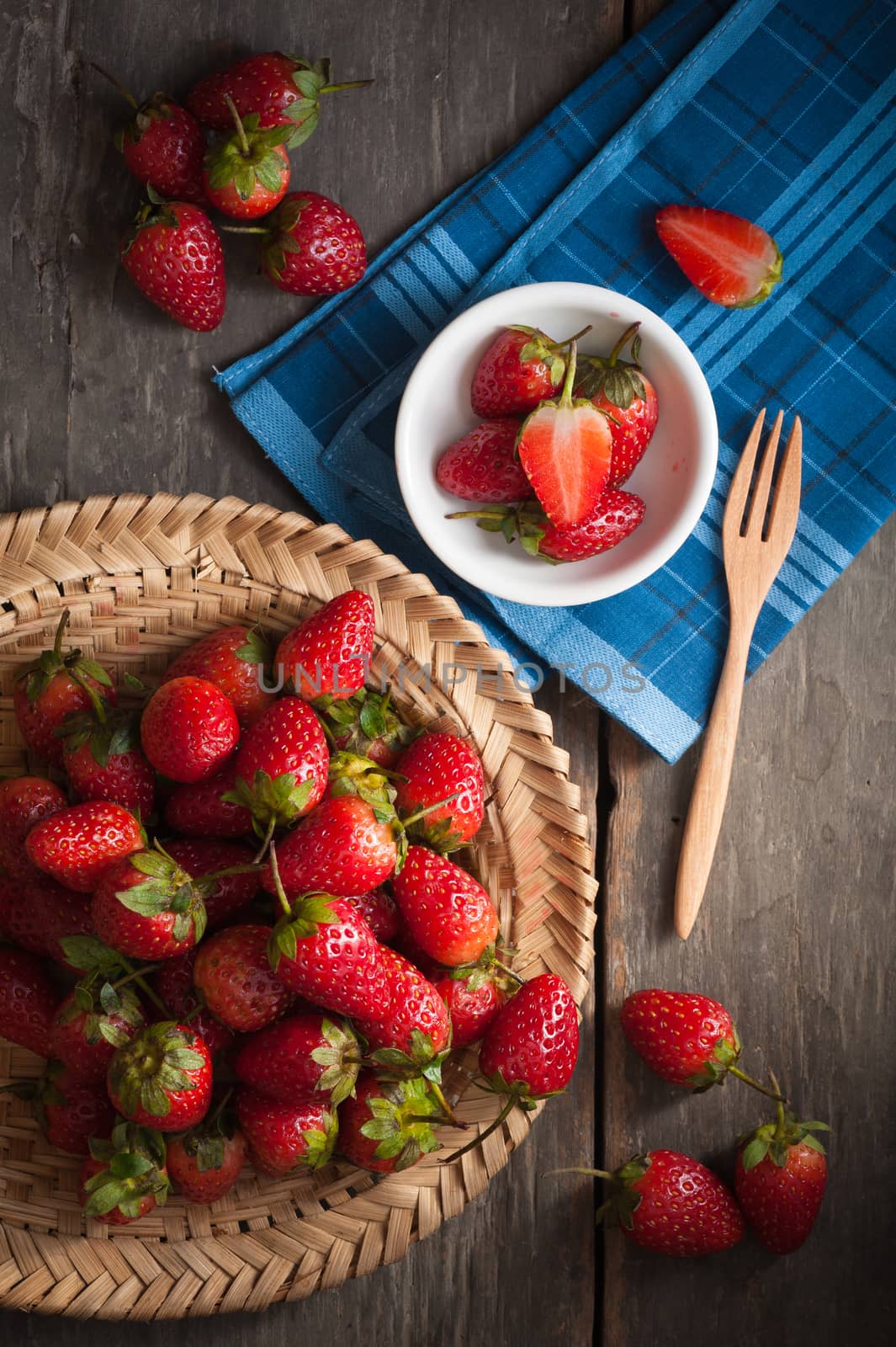 Strawberries on wood background in vintage style with low key scene.