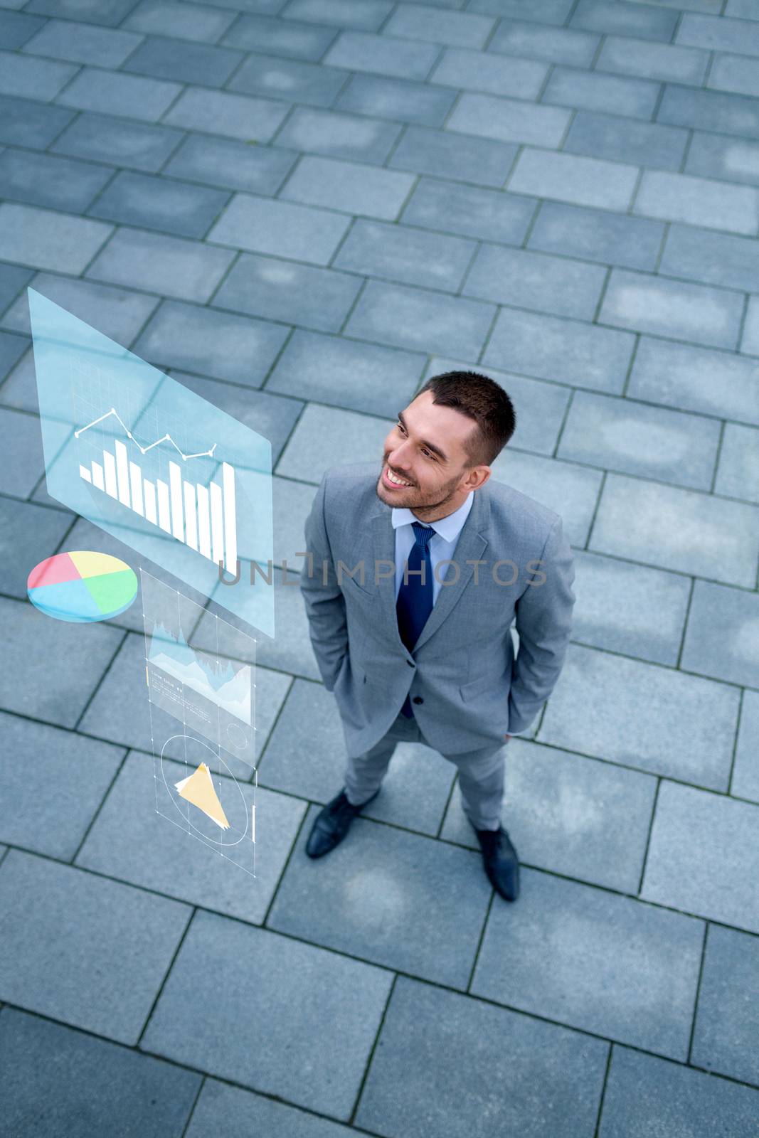 smiling businessman with chart outdoors from top by dolgachov