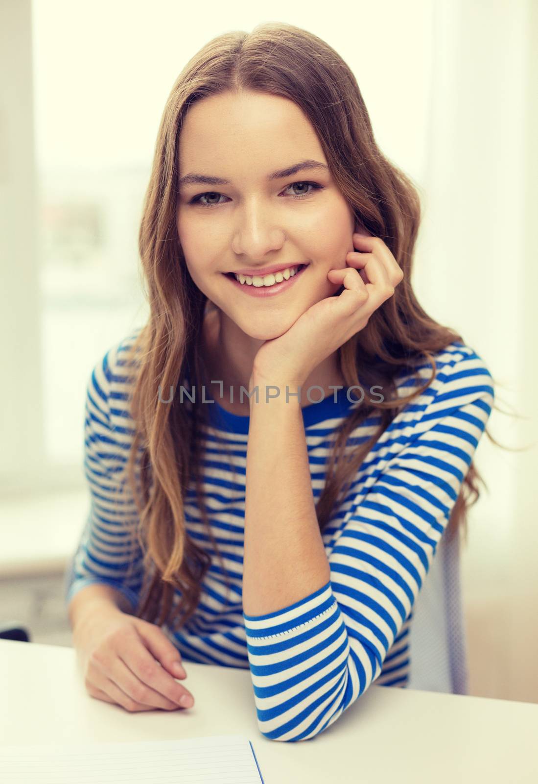 smiling teenage girl with notebook at home by dolgachov