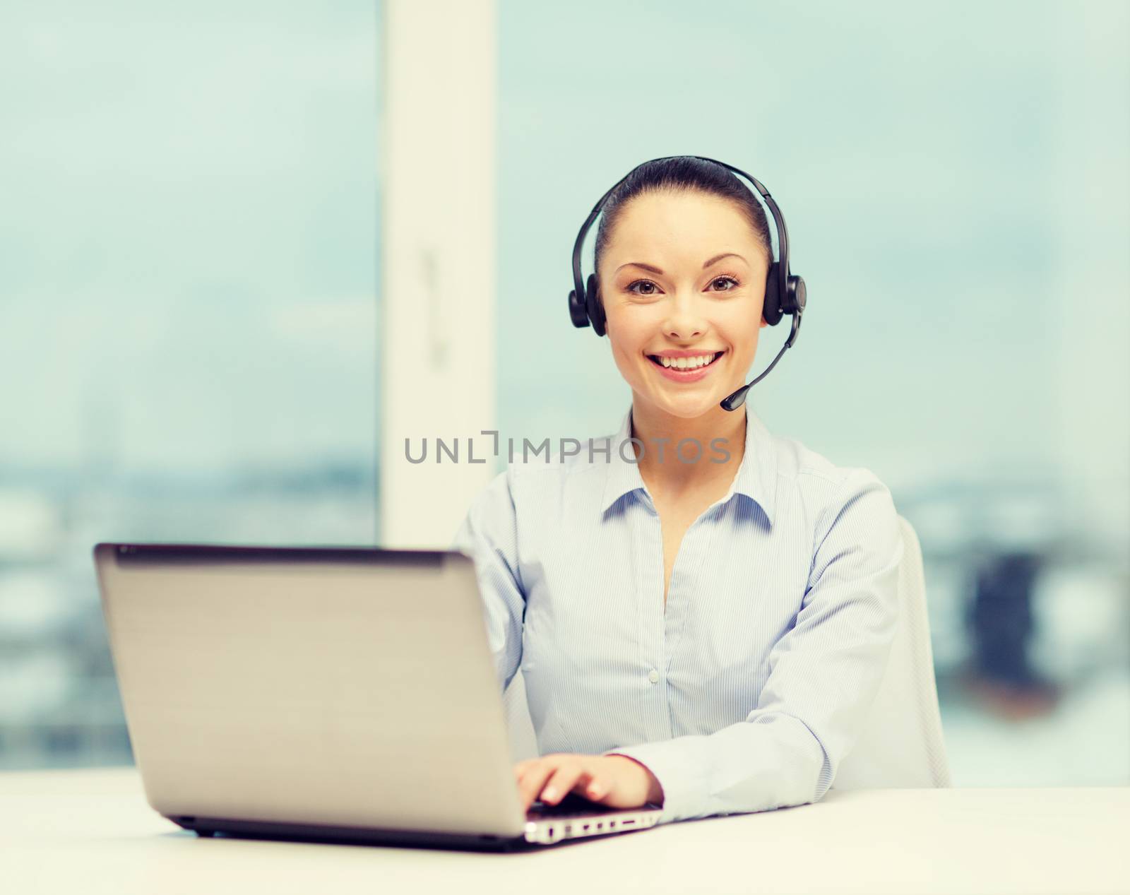 business, communication and call center concept - friendly female helpline operator with headphones and laptop computer